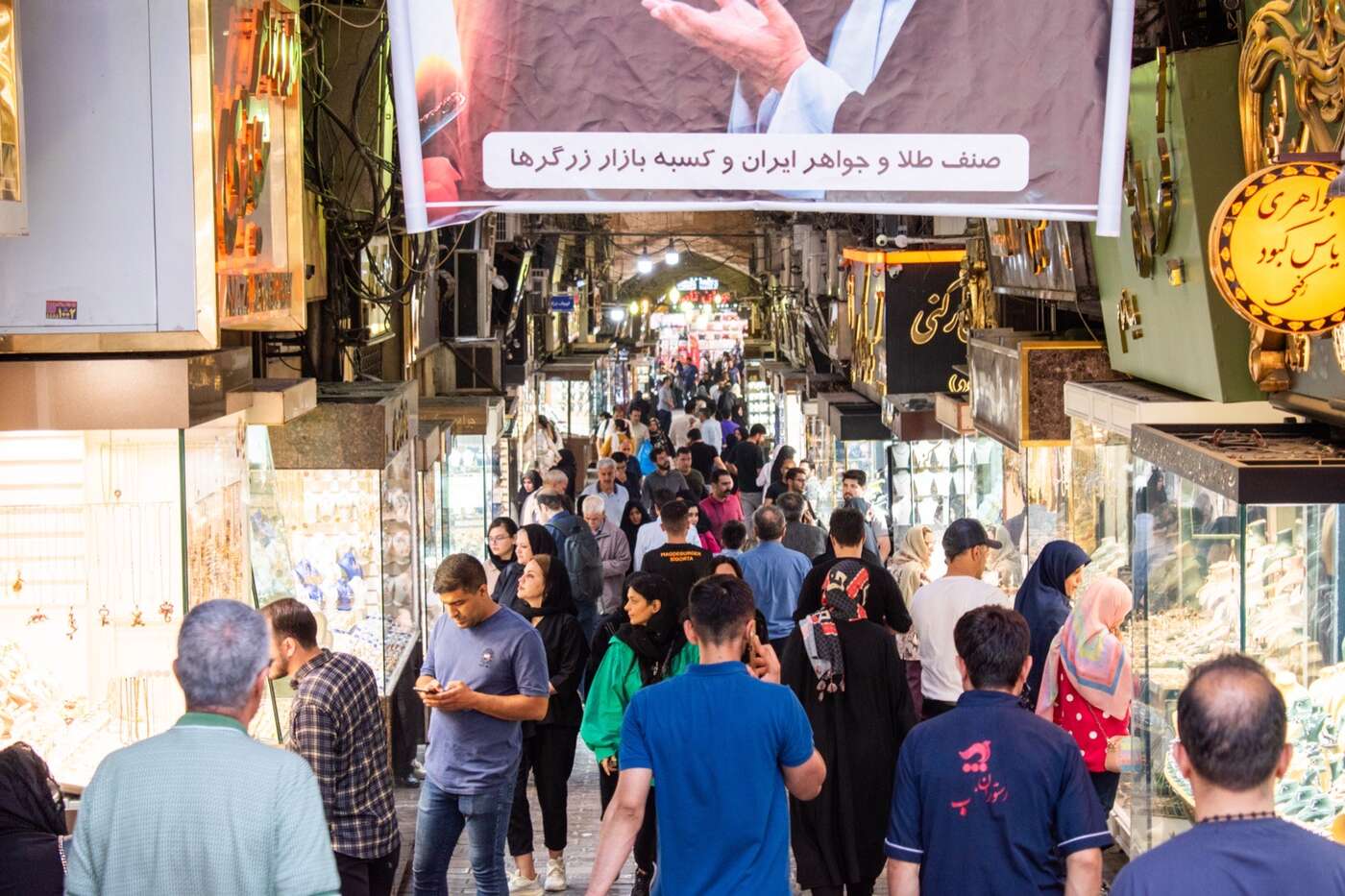 خریداران در راهروی طاقدار و شلوغ بازار بزرگ تهران، با مغازههای جواهرفروشی