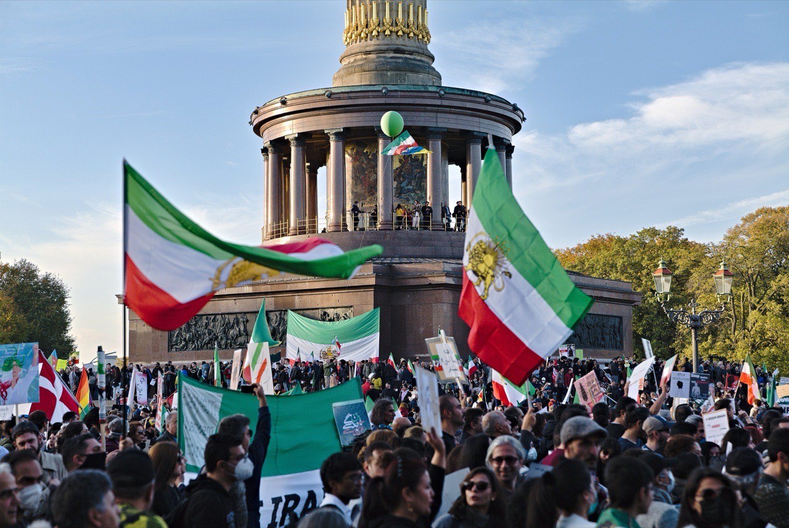 Iranian Lion-and-Sun flags and protest placards at the foot of Berlin's Victory Column, 2022.